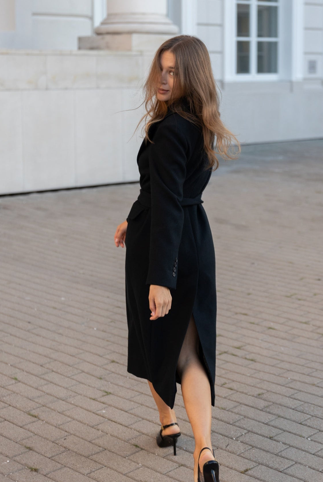 Długi płaszcz dla kobiet petite do 164 cm wzrostu, ujęcie bokiem w miejskiej stylizacji.