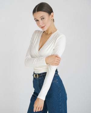 Biała bluzka dla niskich kobiet do 164 cm wzrostu, stylizacja z granatowymi jeansami.
