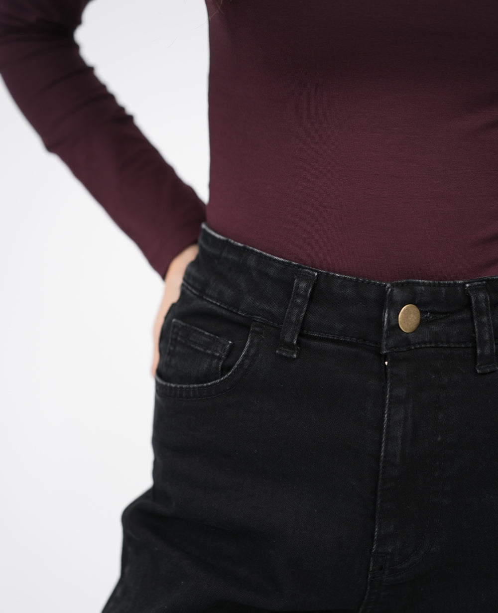 Czarne jeansy flare dla niskich kobiet do 164 cm wzrostu, stylizacja przodem z kopertową bluzką.