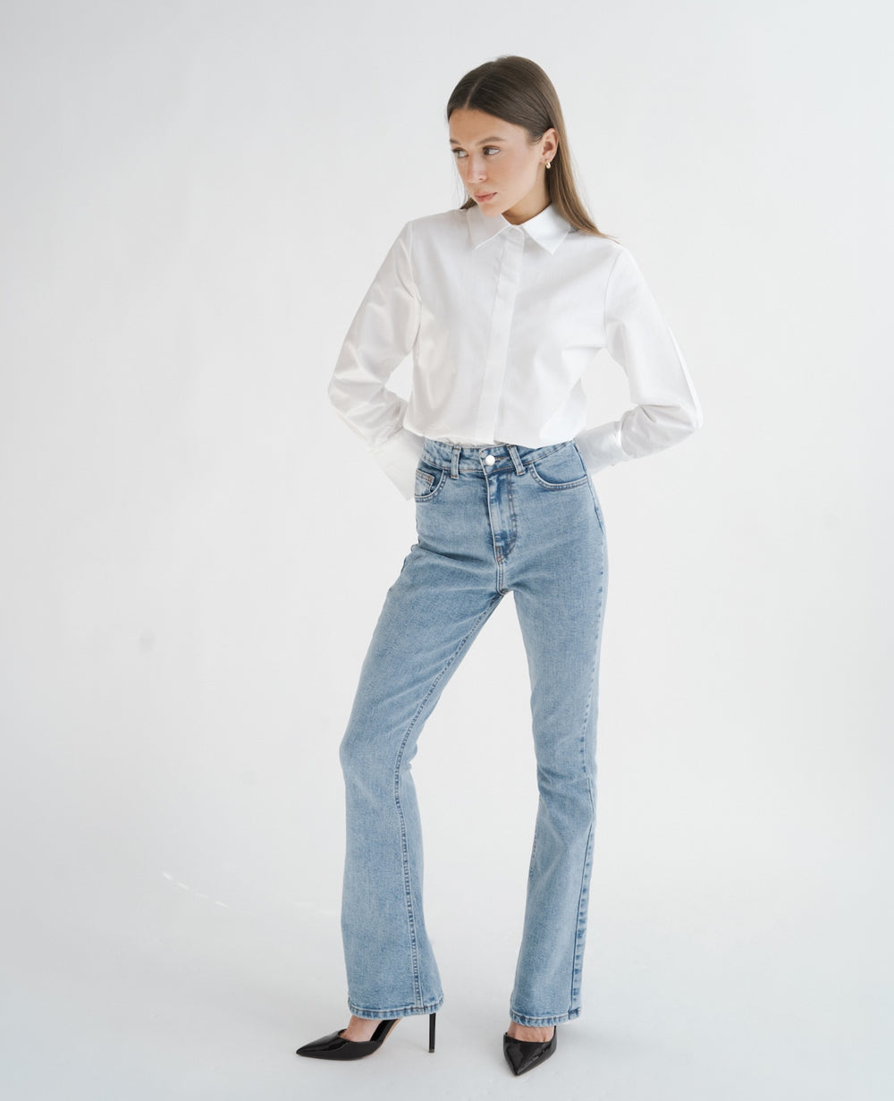 Jasne jeansy flare petite dla niskich kobiet do 164 cm wzrostu, stylizacja z białą koszulą.