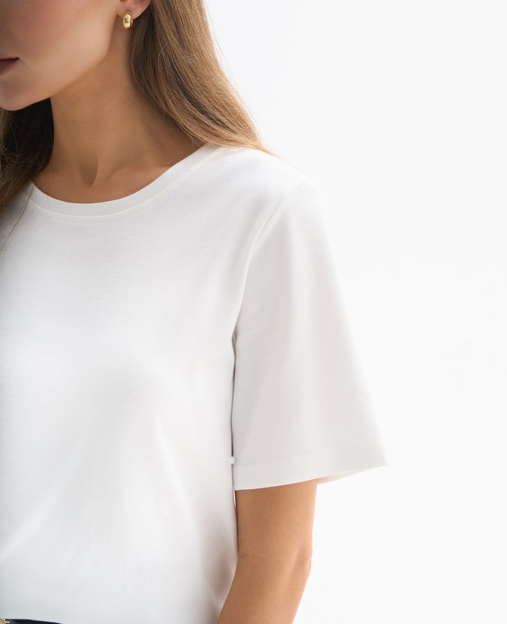 Biały T-shirt dla niskich kobiet – klasyczny fason z krótkim rękawem w stylizacji z jeansami.