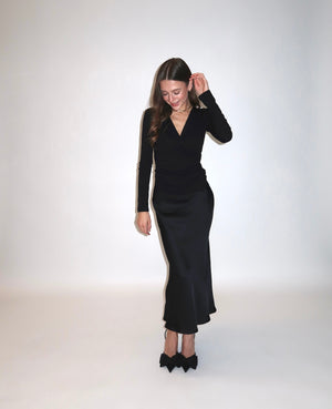 Elegancki czarny zestaw petite dla niskich kobiet do 164 cm wzrostu, kopertowa bluzka i długa spódnica przodem.