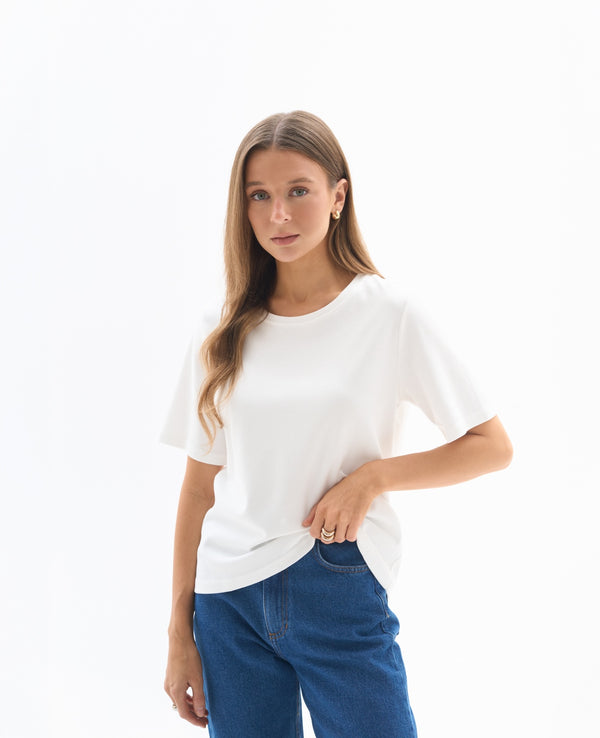 Biały T-shirt dla niskich kobiet – klasyczny fason z krótkim rękawem w stylizacji z jeansami.
